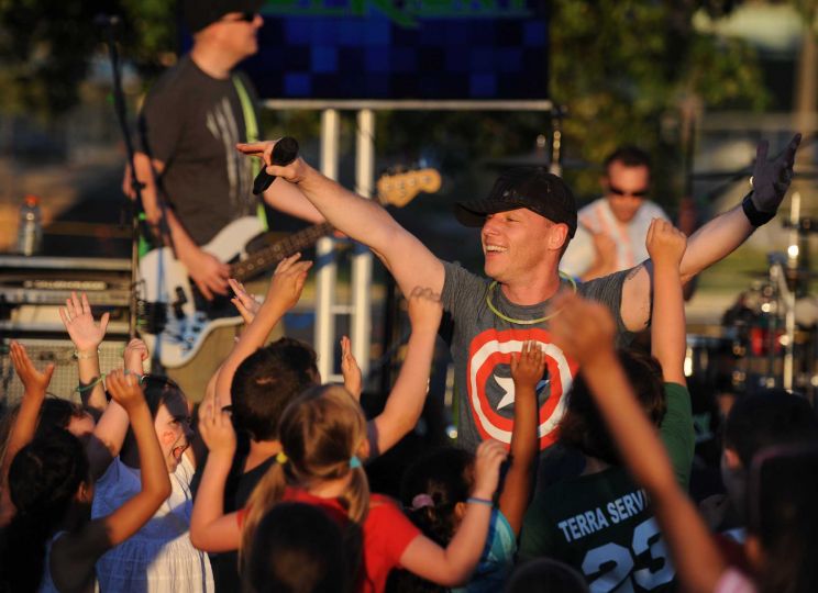Picture of band member performing at outdoor concert.
