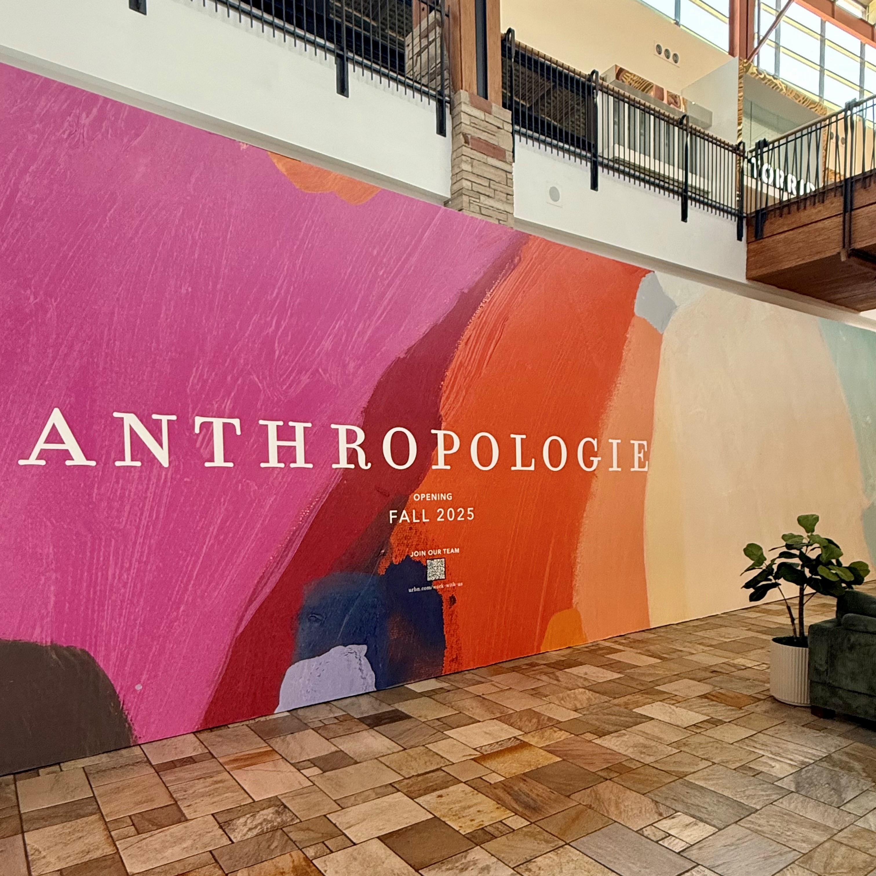 Colorful store barricade with text reading "Anthropologie opening fall 2025"