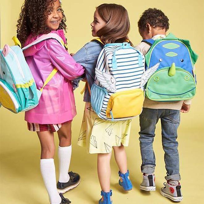 kids wearing backpacks and linking arms