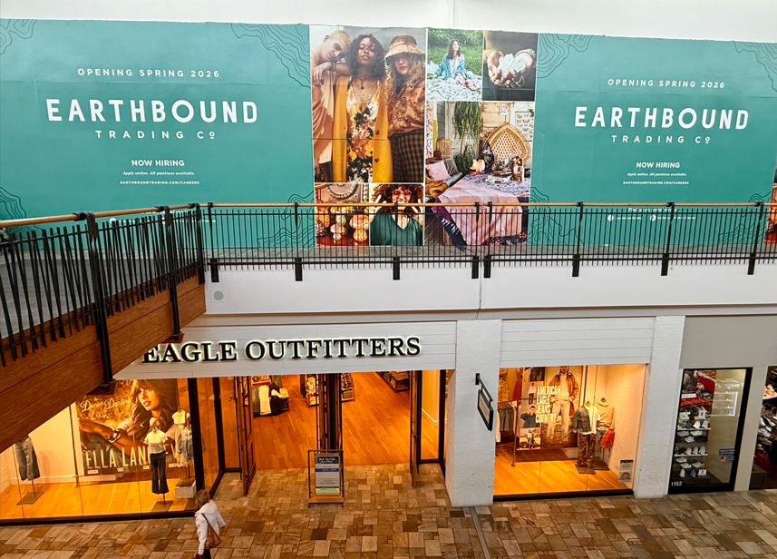 Mall interior with an Eagle Outfitters storefront below a large banner advertising Earthbound Trading Co opening Spring 2026.