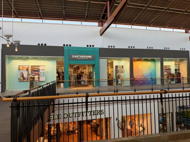 Mall interior with an Eagle Outfitters storefront below a large banner advertising Earthbound Trading Co opening Spring 2026.