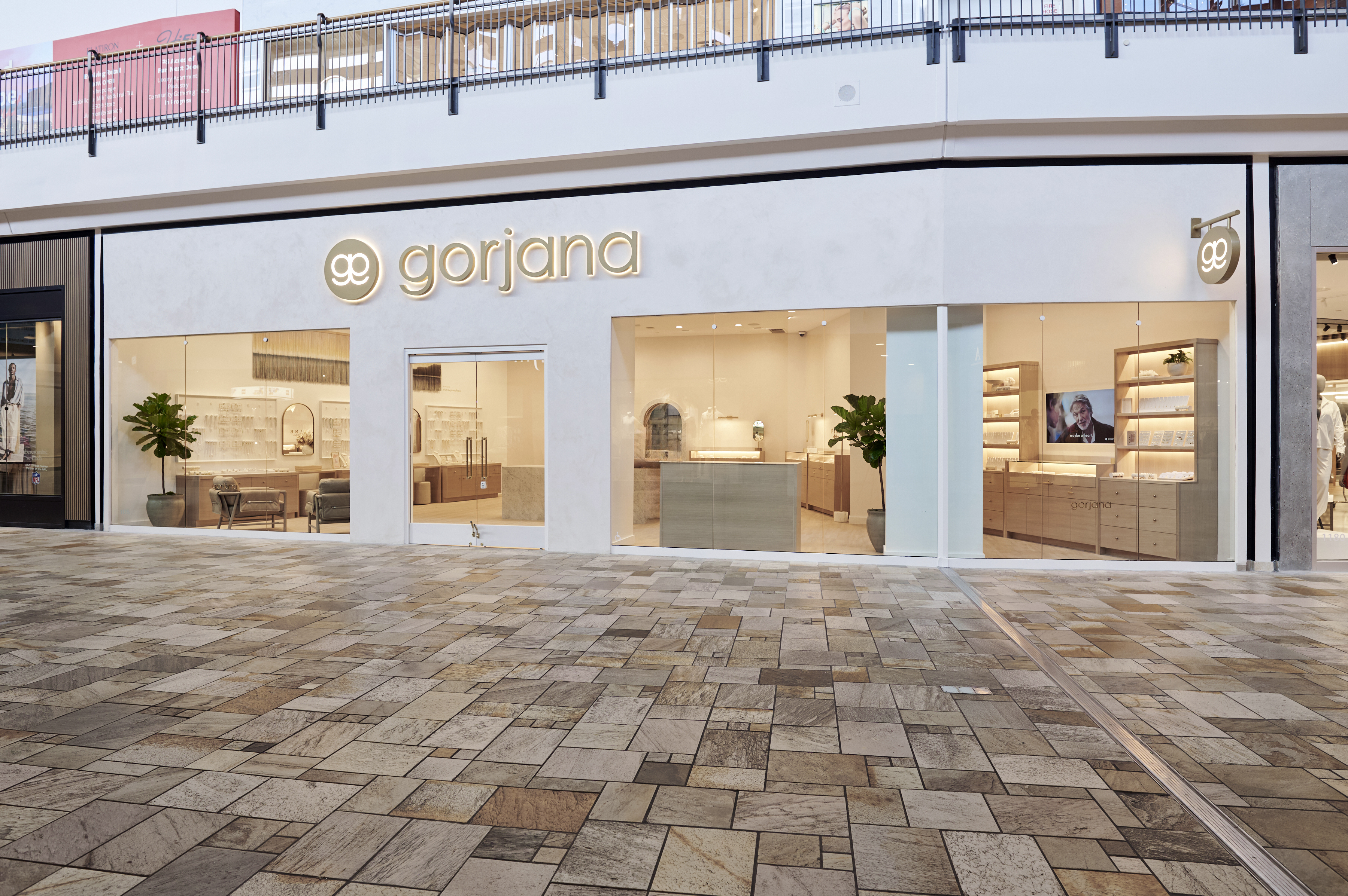 Storefront barricade for gorjana with several mall shoppers walking