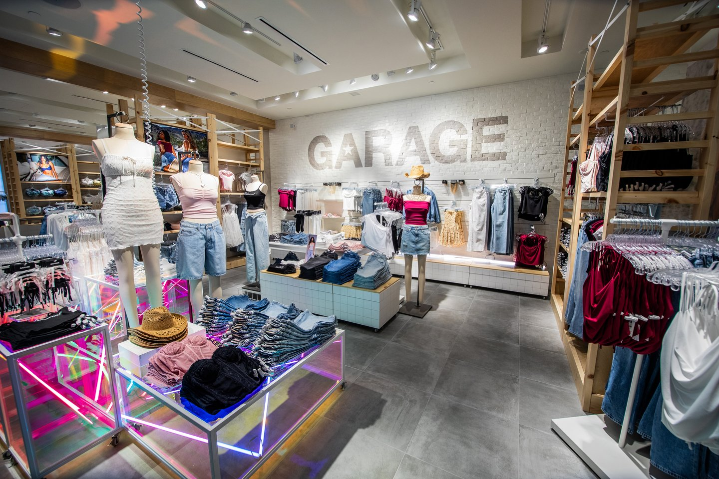Interior of a clothing store with neon lights and wall that reads "Garage"