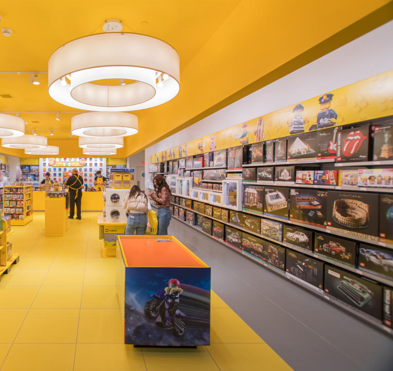 A brightly lit Lego store with yellow flooring and ceiling