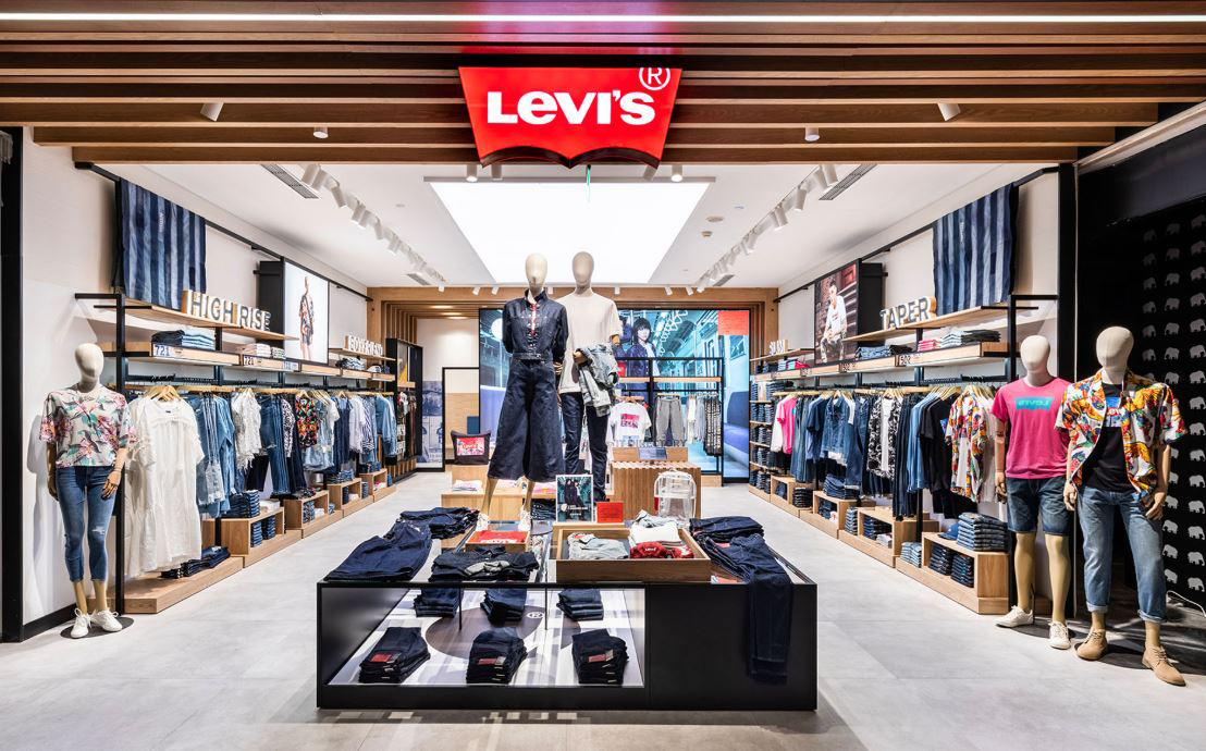 Interior of a Levi's store with a Levi's red sign at the top middle of the store.