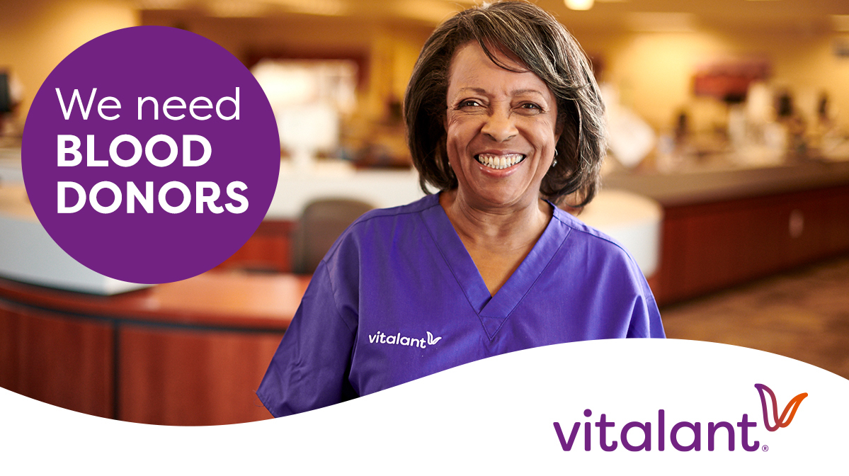 Woman wearing purple scrubs and smiling. Purple circle with text reading ' We need blood donors'. Vitalant logo on the bottom right corner. 