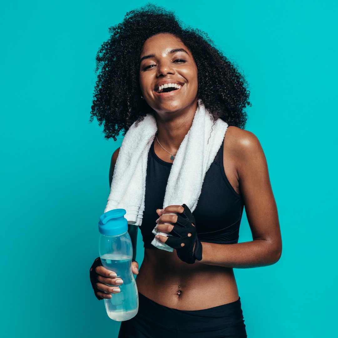 A woman in workout gear with towel and water bottle
