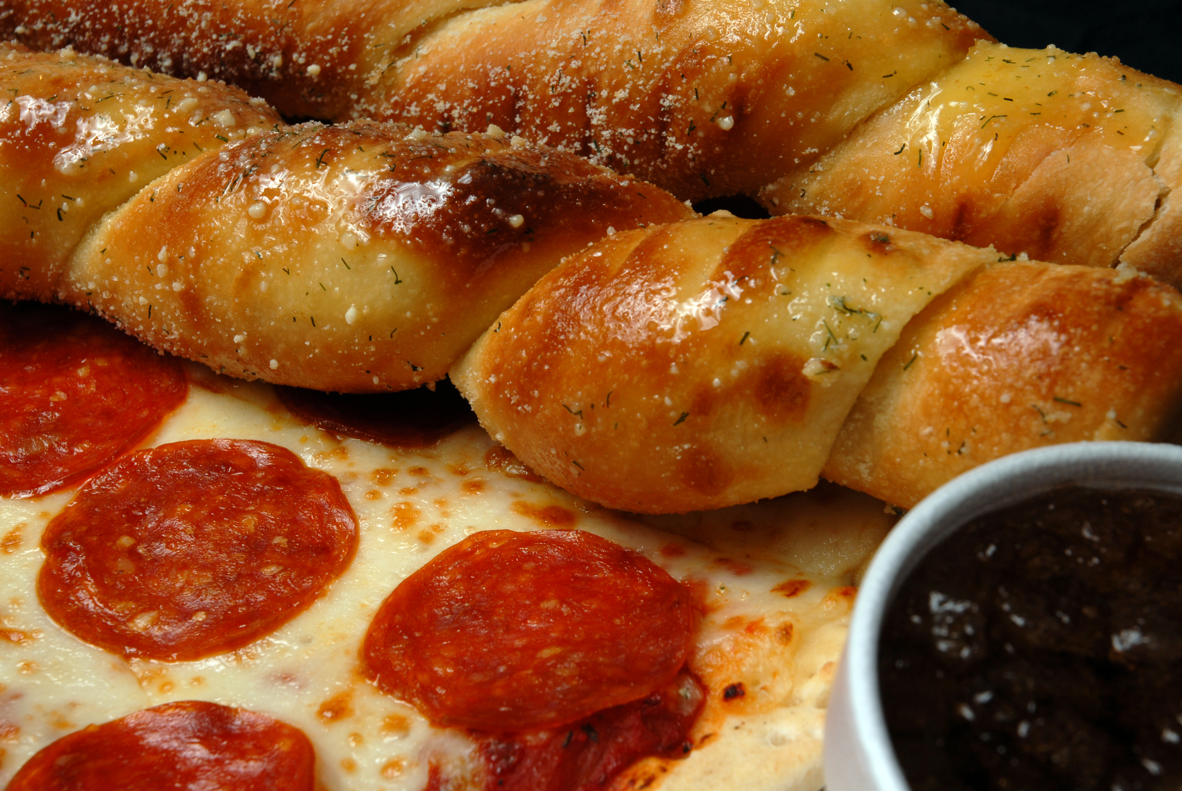 Pizza and bread sticks with sauce