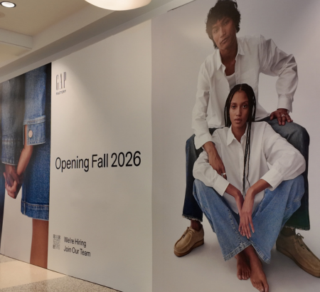 Gap's white and grey storefront barricade with 1 female and 1 male model posing in white shirts and denim jeans