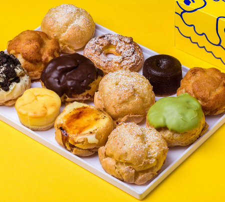 Assorted cream puffs on a plate.