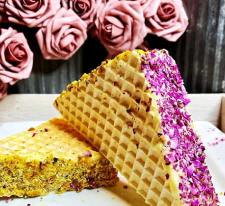 Ice cream sandwiches in a waffle cone on a platter with roses in the background.