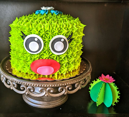 Cake designed to look like a cactus with a face. 