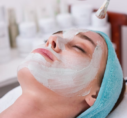 Woman receiving a facial with product on her face.