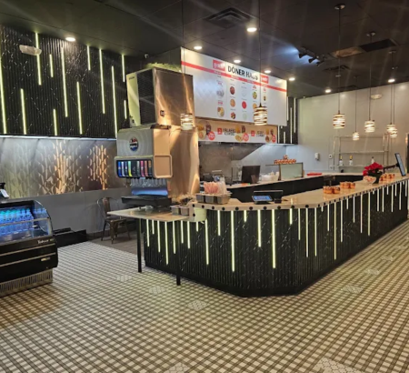 Restaurant dining room, cooktops and soda machine.