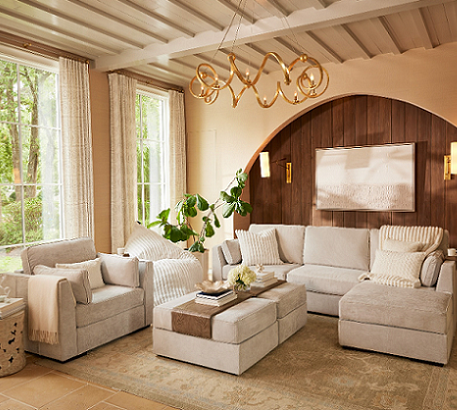 Room with wood paneling, natural tones and a white sectional and loveseat. 