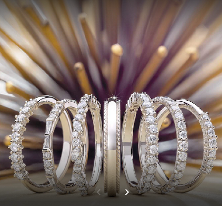 Gold plated rings with diamonds lined up on a display board.