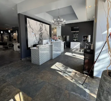 A reception area in a salon with a white and gray veined marble accent piece on the wall.