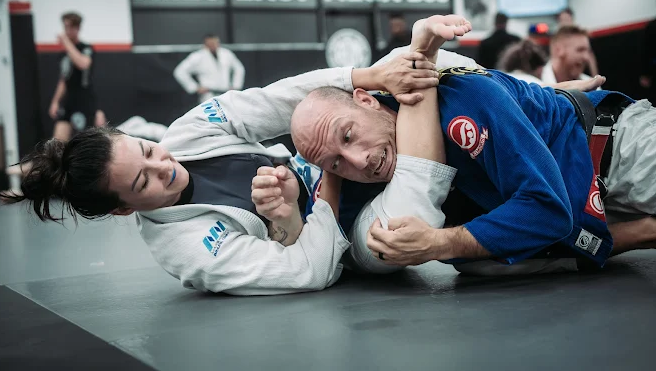 People wrestling on a mat.
