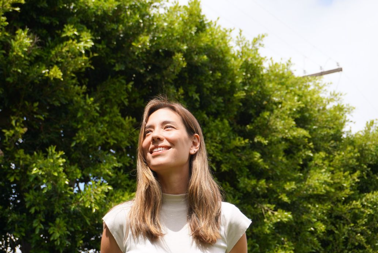 Woman smiling with trees in the background