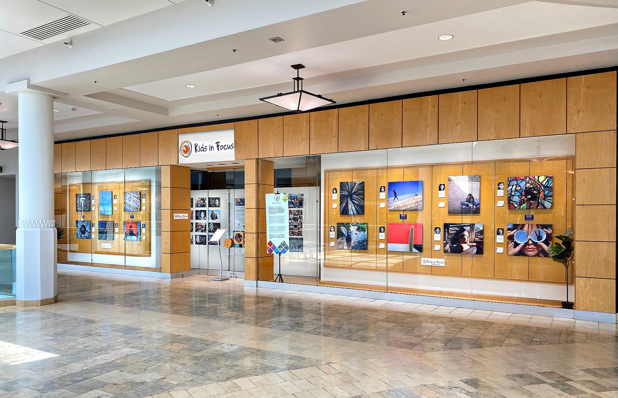 window display with photographs and signage explaining about Kids In Focus non-profit organization