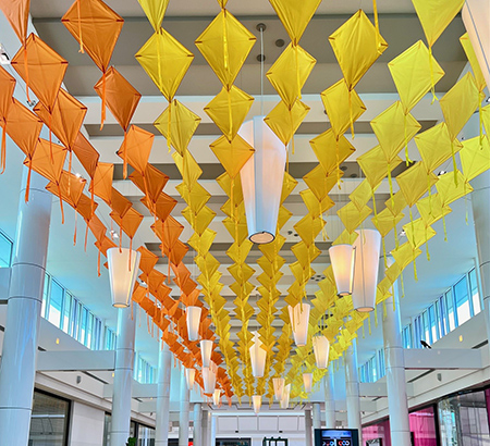 Yellow and orange kites on display as part of the Concourse Hanging Art Exhibit at Tysons Corner Center