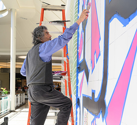 Fernando Osorio painting the mural at Tysons Corner Center