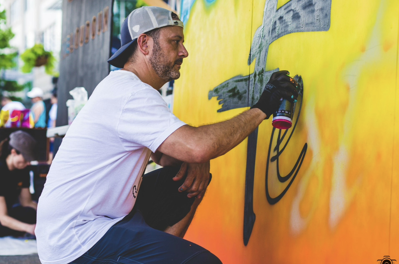 Artist paining graffiti on a wall