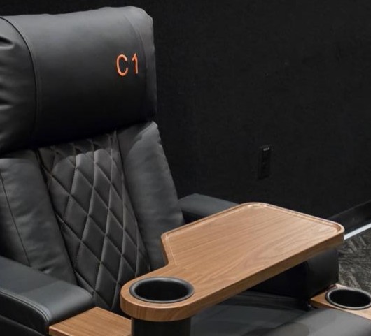 A reclining leather movie seat with a tray.