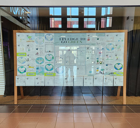 A bulletin board full of earth day pledge sheets, created by local elementary students. 