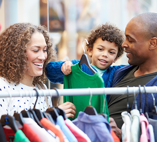 Mother and father clothes shopping with their son