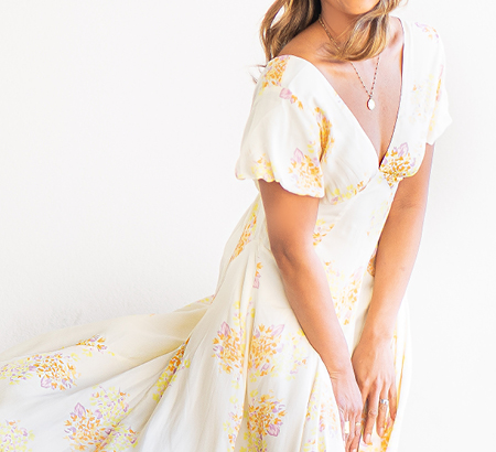 Woman wearing a long, flowy dress with a floral pattern