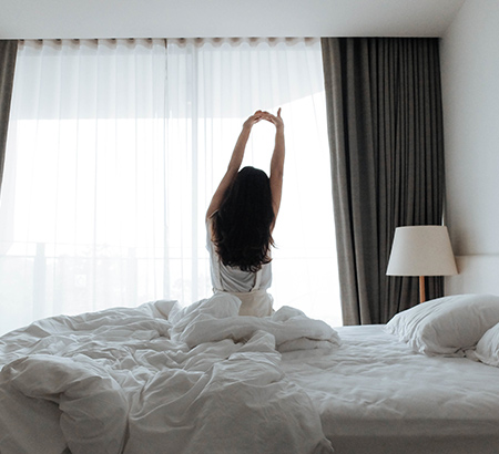 Woman stretching in a hotel bed