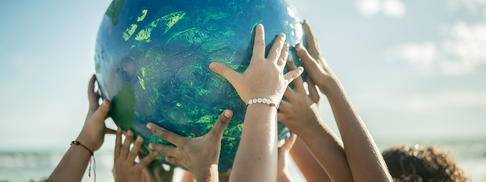 Children's hands holding up a globe