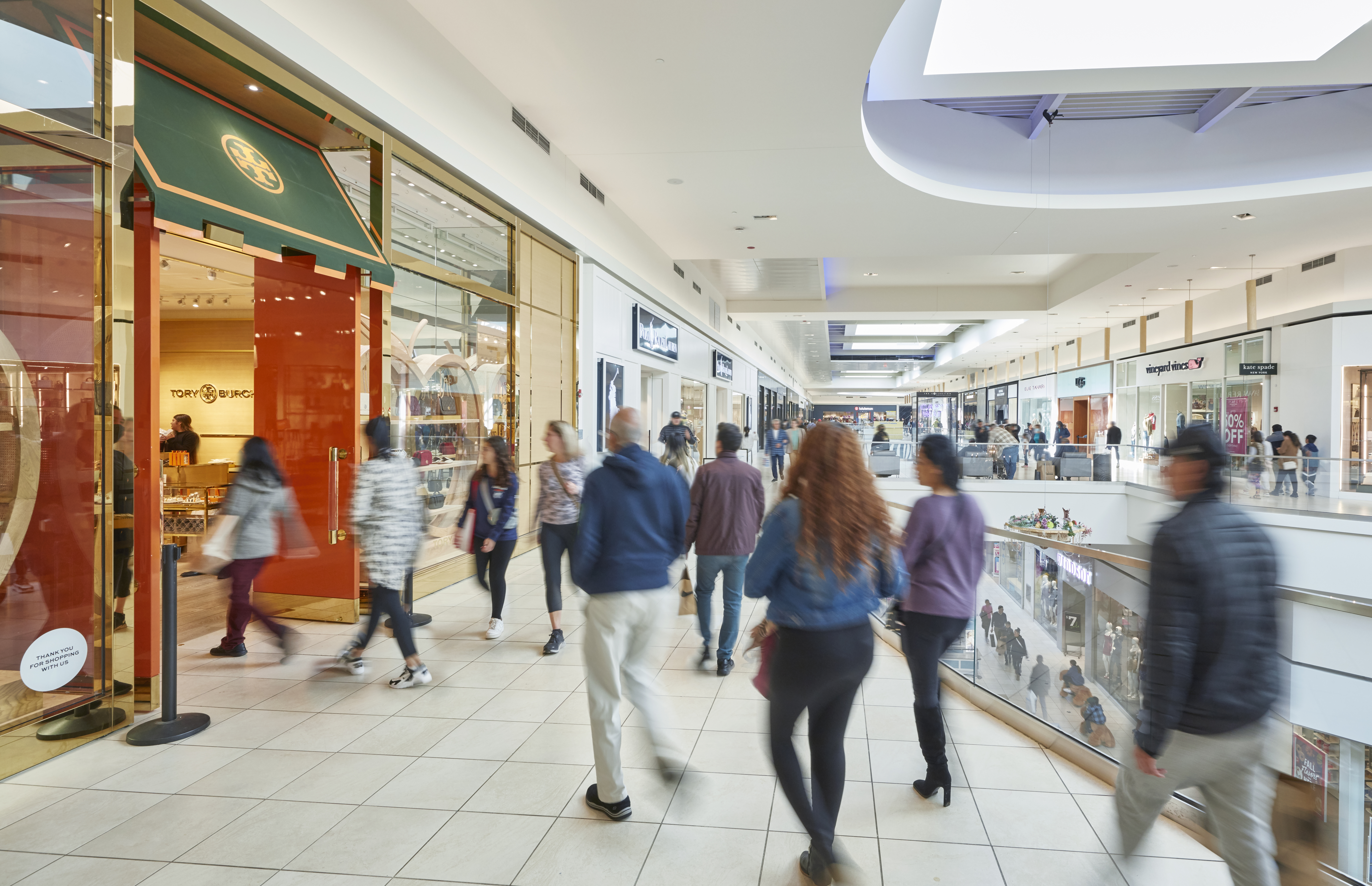Shoppers walking around Fashion Outlets of Chicago in front of Tory Burch and POLO.