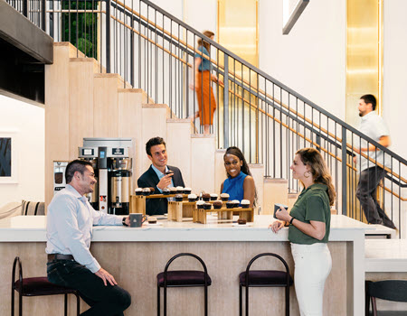 staff sitting at a coffee bar with cupcakes 