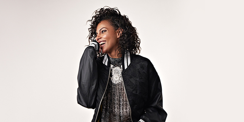 Woman smiling in a black bomber jacket