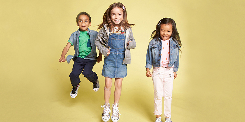 Three children jumping in the air on a yellow background