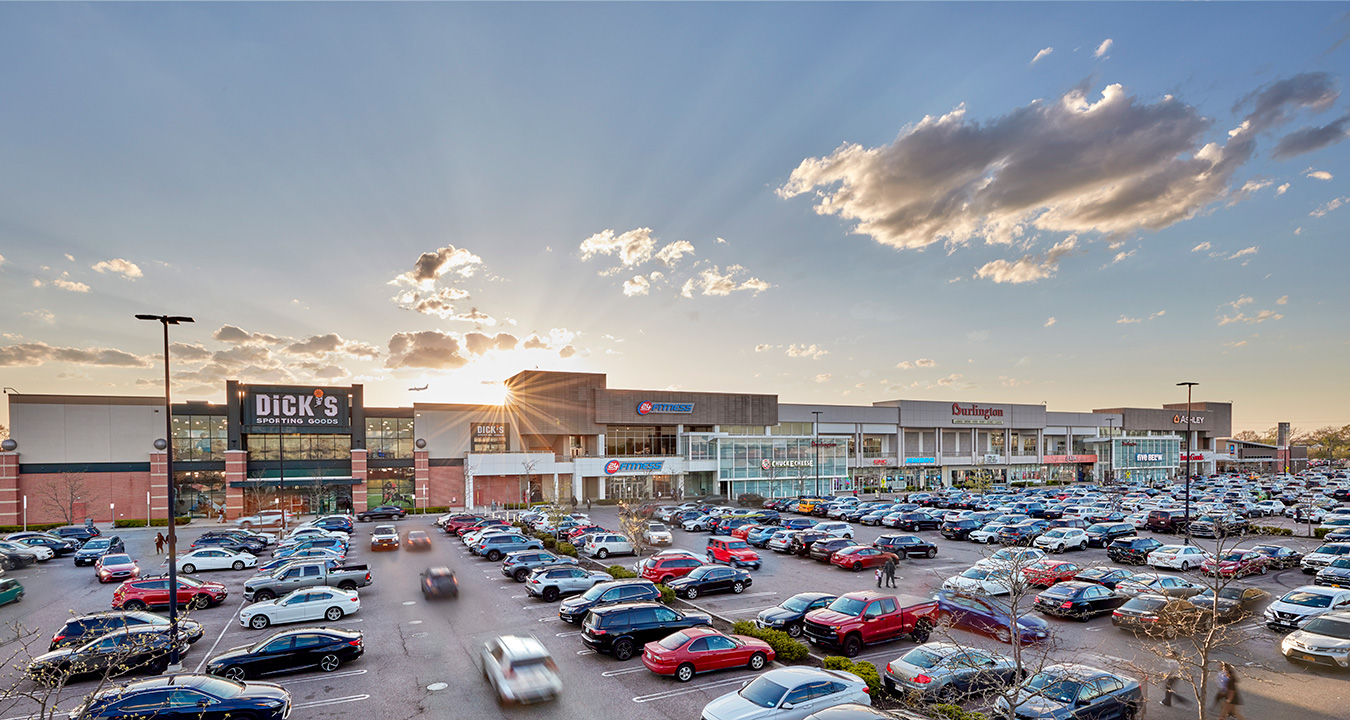 View of the exterior of Green Acres Mall at sunset