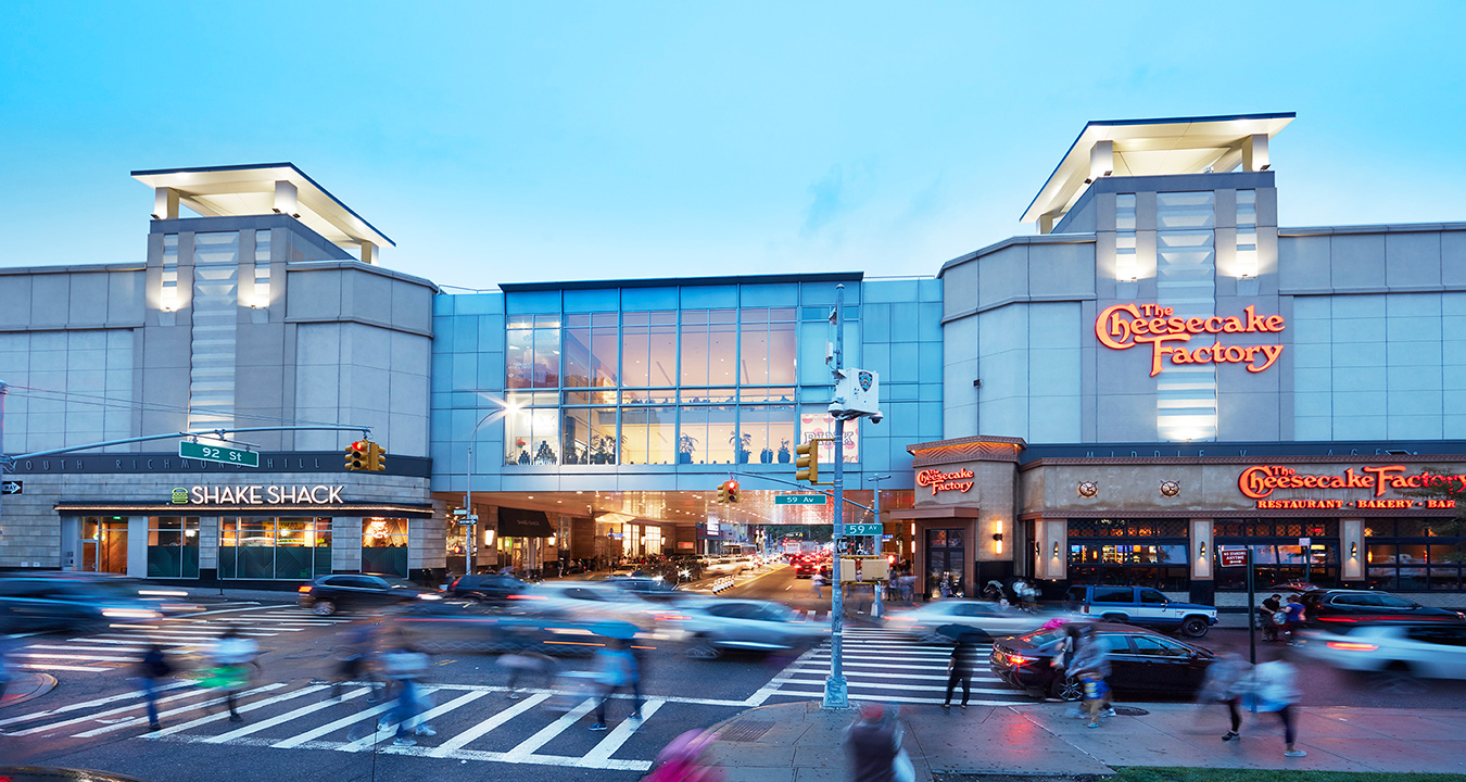 Queens Center's exterior at dusk