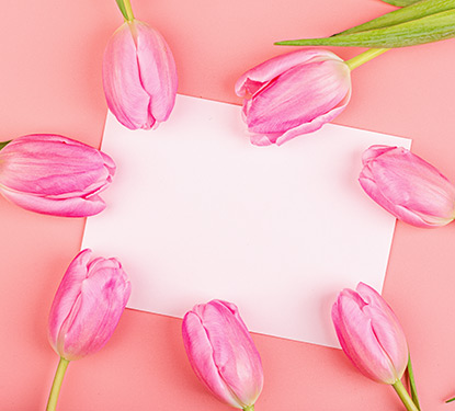 Pink tulips surrounding a greeting card envelope