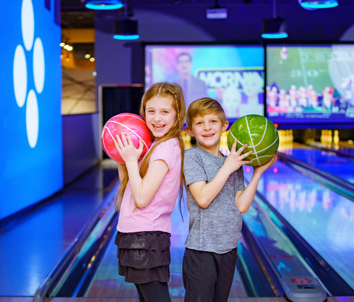 two kids holding bowling balls
