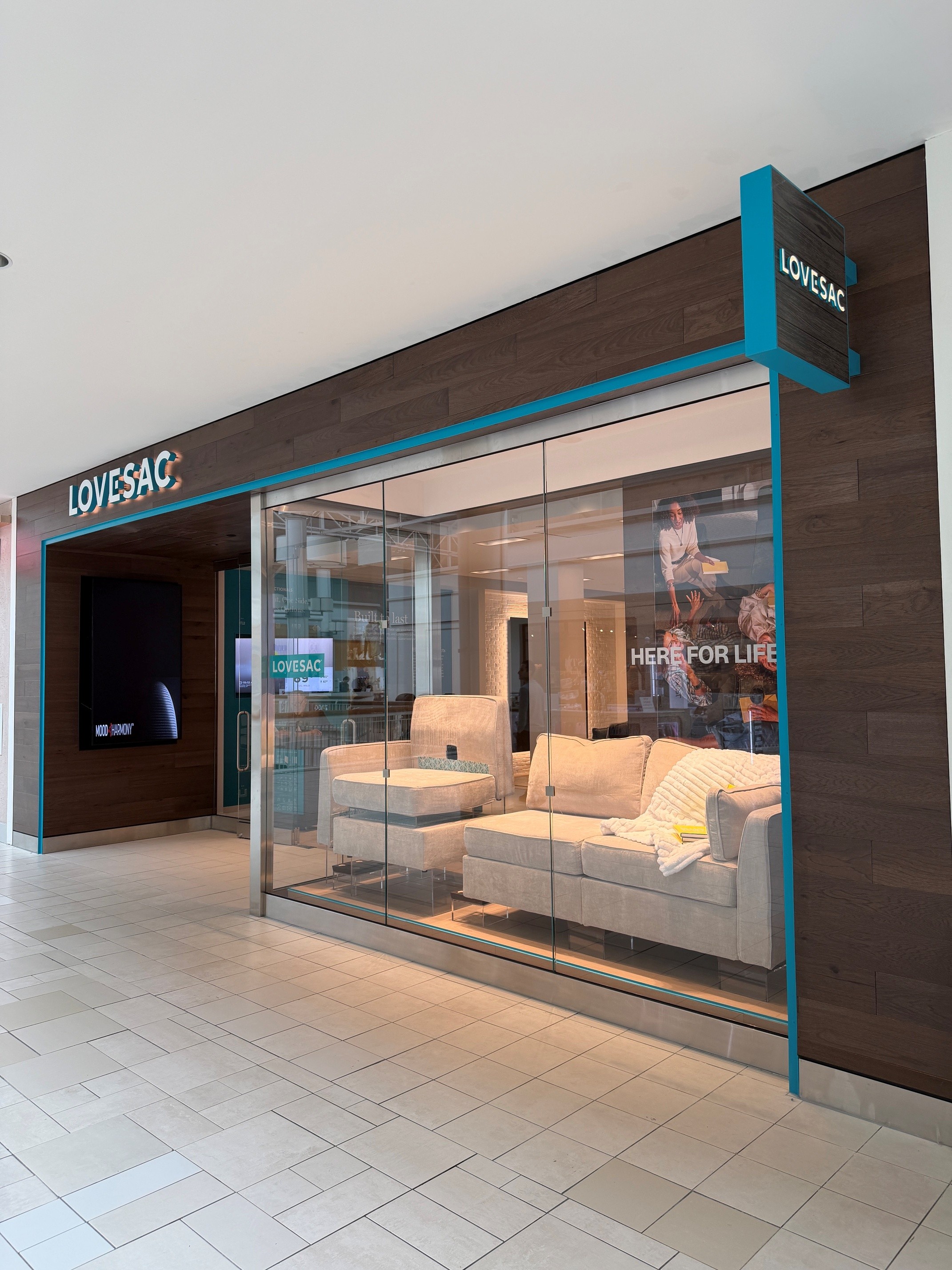 Exterior of newly renovated Lovesac store featuring a tan couch display