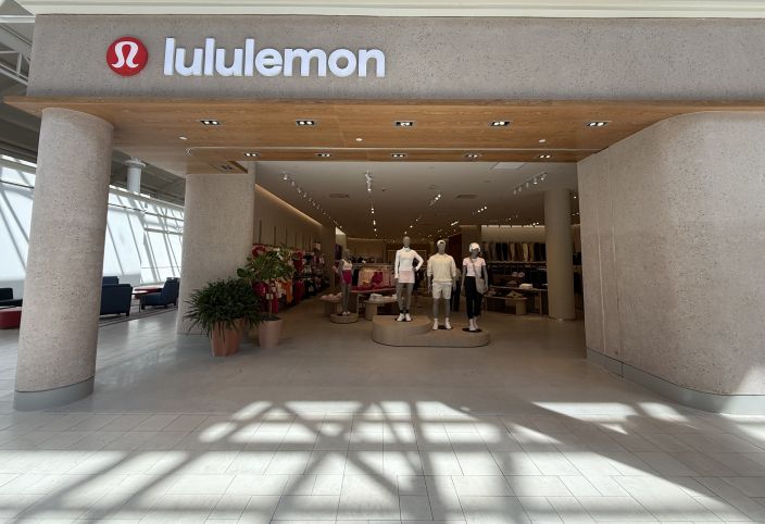 Exterior of newly renovated lululemon store featuring modern design, and mannequins displaying athletic wear inside.