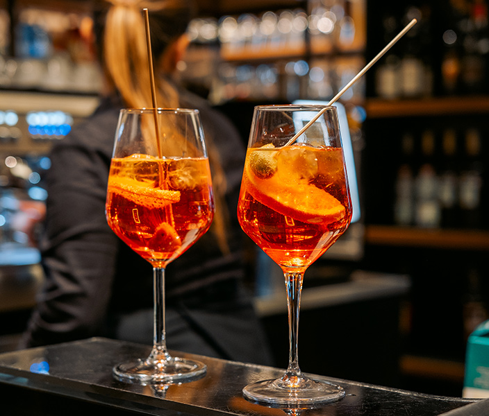 Two cocktails resting on a restaurant bar