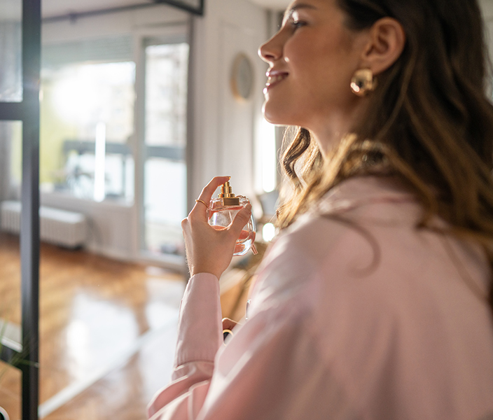 A woman spraying perfume on herself