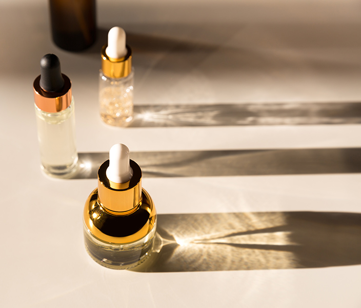 Bottles of beauty serums casting shadows