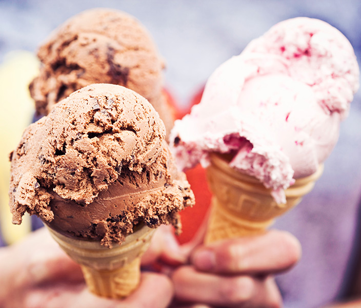 Hands holding three ice cream cones