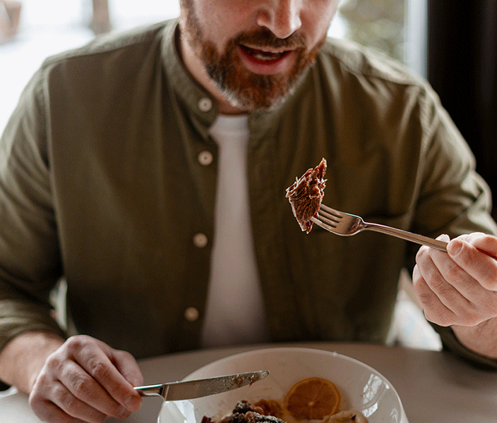 A man eating beef in a restaurant