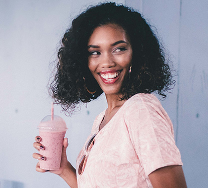 A young woman drinking a fresh smoothie
