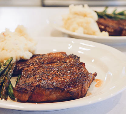 Cooked steak with mashed potatoes and asparagus.